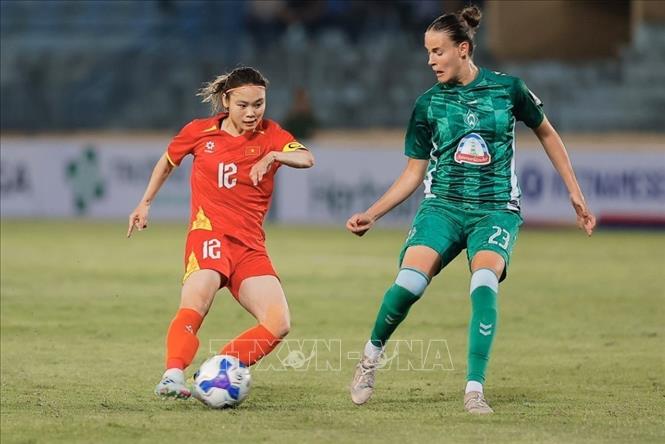 Pha tranh bóng giữa đội trưởng Hải Yến (số 12, Việt Nam) và Nemeth (số 23, Werder Bremen). Ảnh: Minh Quyết - TTXVN