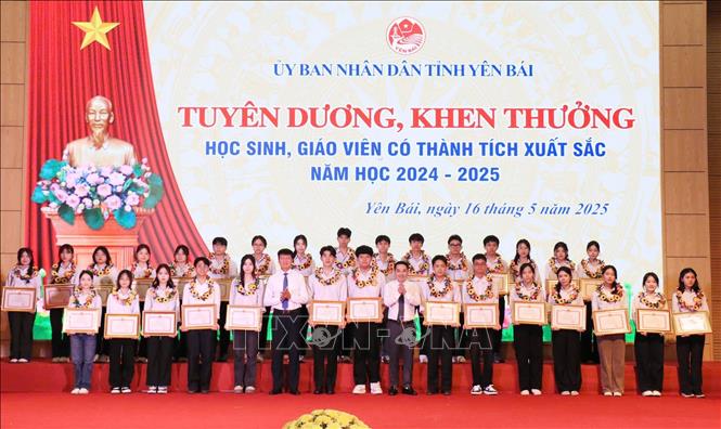 Bí thư Tỉnh ủy Yên Bái Trần Huy Tuấn và Chủ tịch UBND tỉnh Yên Bái Nguyễn Tuấn Anh trao tặng Bằng khen của Chủ tịch UBND tỉnh cho học sinh có thành tích xuất sắc. Ảnh: Đinh Thùy - TTXVN