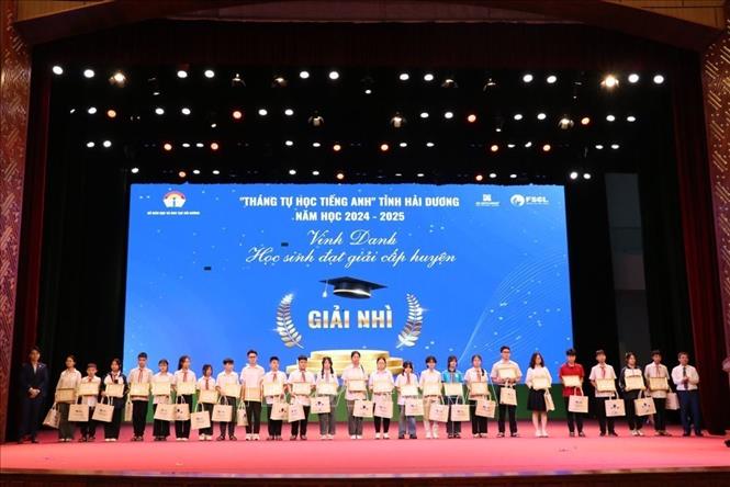 Trao giải cho học sinh đoạt giải nhì cấp huyện tham gia chương trình Tháng tự học tiếng Anh. Ảnh: Mạnh Minh – TTXVN