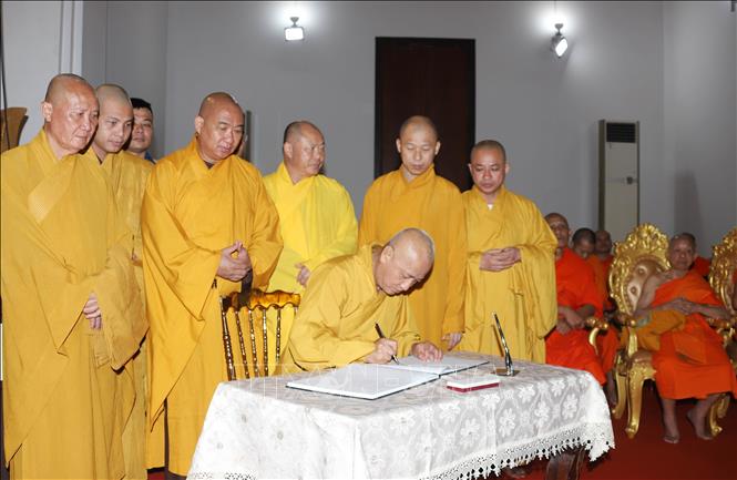 Hòa thượng Thích Huệ Thông, Phó Chủ tịch Hội đồng Trị sự, Trưởng ban Pháp chế Trung ương GHPGVN cùng Đoàn ghi sổ tang. Ảnh: Xuân Tú - PV TTXVN tại Lào