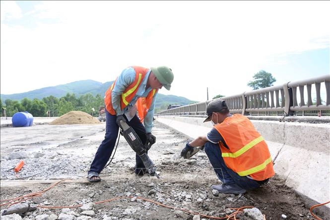 Công nhân thi công tại vị trí khe co giãn của cầu. Ảnh: Hữu Quyết - TTXVN