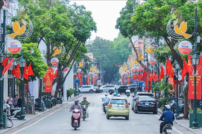 Đường Tràng Tiền rực đỏ cờ, băng rôn chào mừng kỷ niệm 135 năm Ngày sinh Chủ tịch Hồ Chí Minh. Ảnh: Hoàng Hiếu - TTXVN