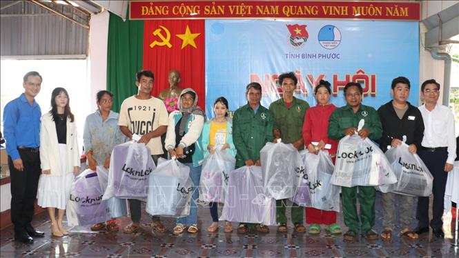 Ban tổ chức trao quà cho người dân có hoàn cảnh khó khăn tại Lễ ra quân. Ảnh: Nhật Bình – TTXVN