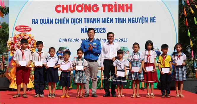 Ban tổ chức trao học bổng cho học sinh vượt khó học tốt tại Lễ ra quân Chiến dịch. Ảnh: Nhật Bình – TTXVN