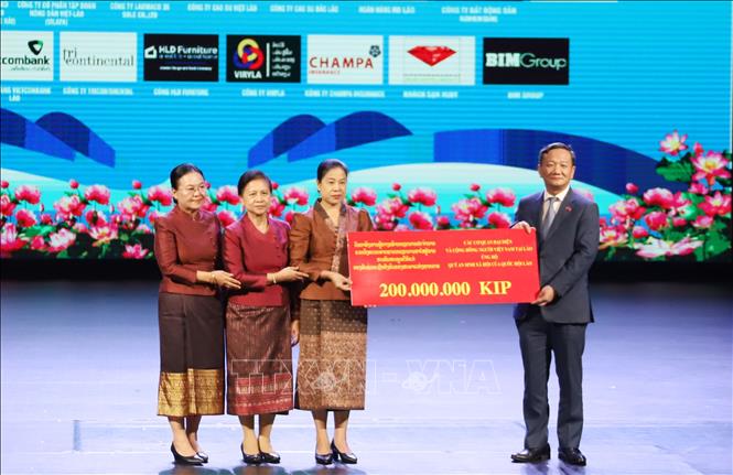 Đại sứ Việt Nam tại Lào Nguyễn Minh Tâm trao tiền từ bán đấu giá tranh lá Bồ Đề ủng hộ Quỹ An sinh xã hội của Quốc hội Lào. Ảnh: Xuân Tú - PV TTXVN tại Lào