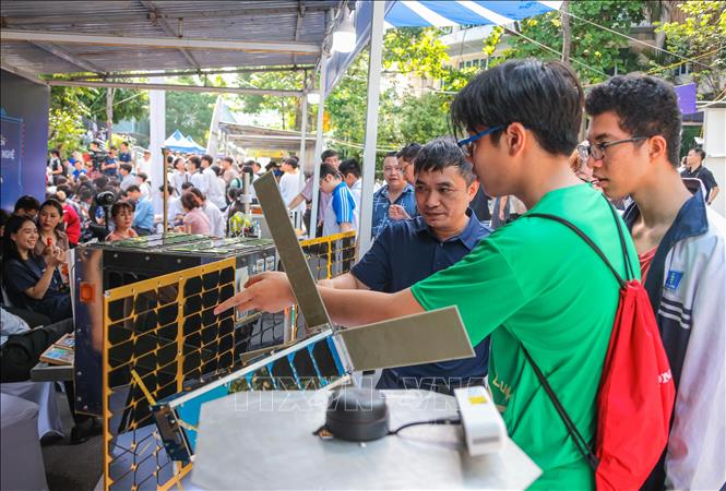 Học sinh tìm hiểu về các vệ tinh tại gian hàng trưng bày sản phẩm khoa học của Viện Hàn lâm Khoa học và Công nghệ Việt Nam. Ảnh: Hoàng Hiếu - TTXVN