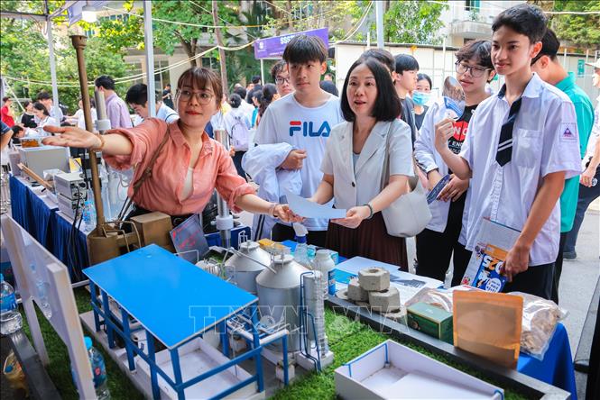 Học sinh và phụ huynh tìm hiểu về các ứng dụng khoa học và công nghệ vào đời sống. Ảnh: Hoàng Hiếu - TTXVN