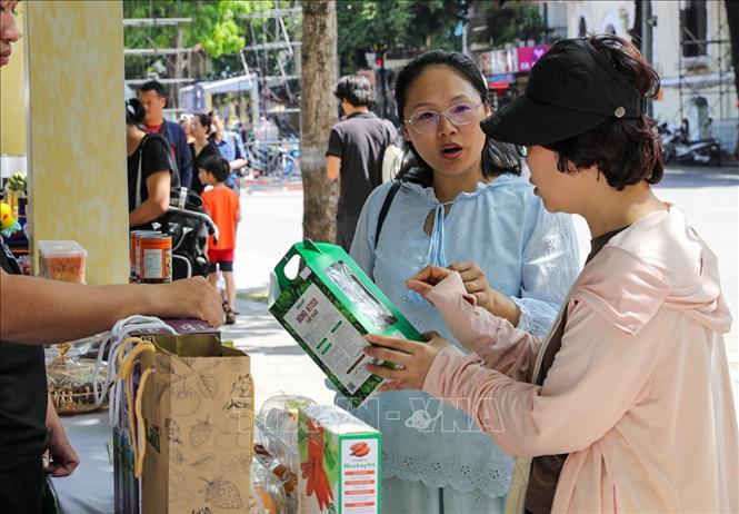 Người dân mua hàng tại 1 trong các gian hàng bày bán các sản phẩm OCOP của tỉnh Lâm Đồng. Ảnh: Khánh Hoà - TTXVN