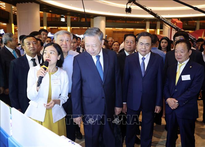 Party General Secretary To Lam and delegates view an exhibition on the sidelines of the conference. VNA Photo