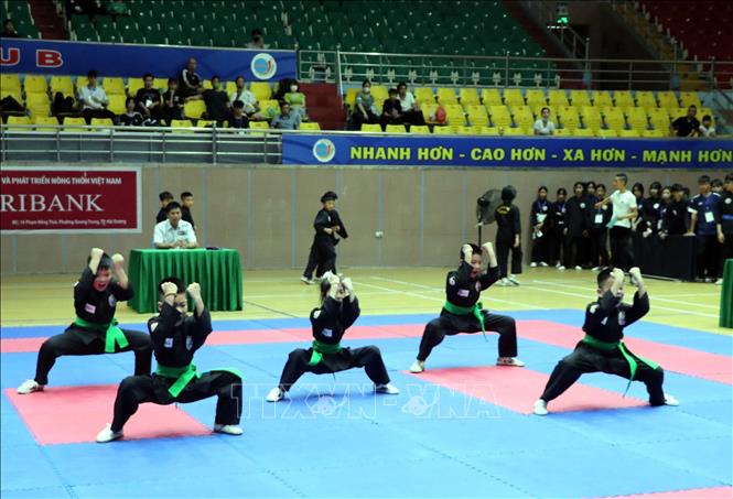 Thi đấu nội dung quyền thuật đồng đội với bài quyền quy định 27 động tác căn bản công. Ảnh: Mạnh Tú - TTXVN