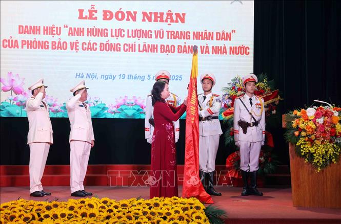 Phó Chủ tịch nước Võ Thị Ánh Xuân gắn huy hiệu “Anh hùng lực lượng vũ trang nhân dân” lên lá cờ truyền thống  Phòng Bảo vệ các đồng chí Lãnh đạo Đảng và Nhà nước thuộc Bộ Tư lệnh Cảnh vệ, Bộ Công an. Ảnh: Phạm Kiên - TTXVN