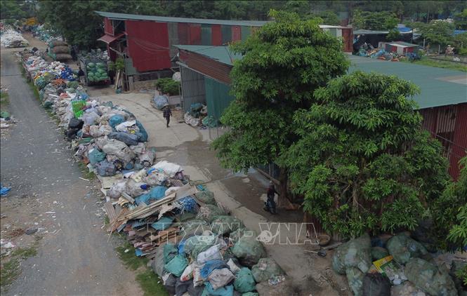 Nghĩa trang của thôn Xà Cầu trở thành nơi tập kết phế liệu đã được phân loại để chờ bán cho nhà máy tái chế. Ảnh: Thành Phương – TTXVN