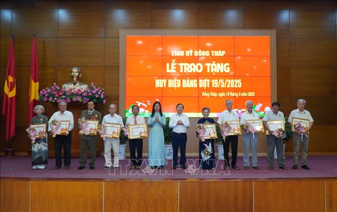 Các đảng viên nhận Huy hiệu 55 năm tuổi Đảng. Ảnh: Nhựt An - TTXVN