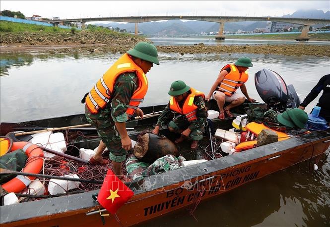 Lực lượng làm nhiệm vụ rà phá bom mìn, vật nổ của Bộ CHQS tỉnh Hòa Bình thực hiện trục vớt phần nửa đầu quả bom có trọng lượng 2000 bảng Anh (gần 1 tấn). Ảnh: Trọng Đạt-TTXVN