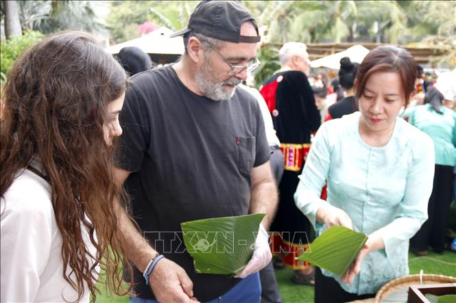 Foreign visitors learn how to make Vietnam's traditional chung cake in Hanoi (square glutinous rice cake). VNA Photo