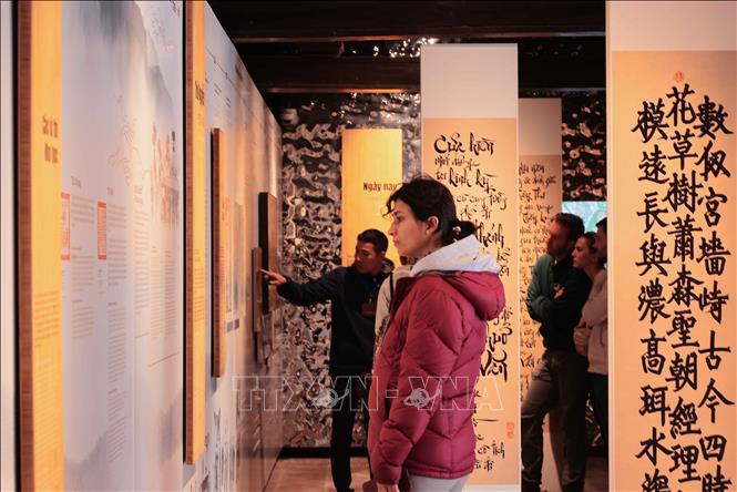 Foreign visitors learn about Vietnamese culture and history at Van Mieu - Quoc Tu Giam in Hanoi. VNA Photo