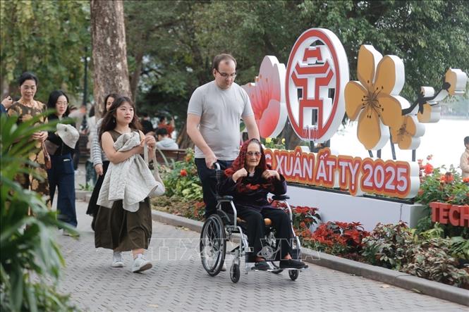 Foreign visitors take a stroll around Hoan Kiem Lake (Sword Lake). VNA Photo