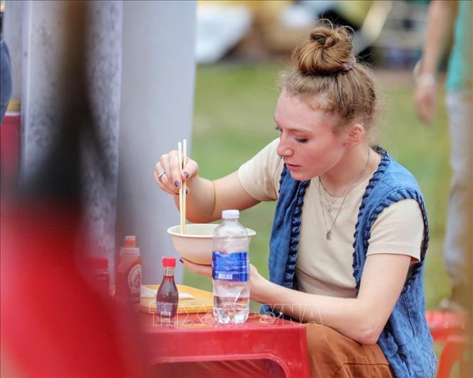 A visitor enjoys a bowl of pho in Hanoi. VNA Photo