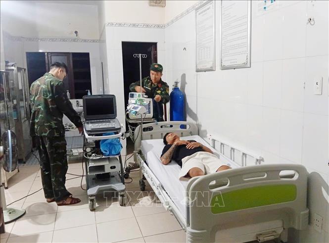 Các y, bác sĩ Trung tâm y tế thị trấn Trường Sa tiến hành thăm khám bệnh cho bệnh nhân Nguyễn Đình Diệm. Ảnh: TTXVN phát