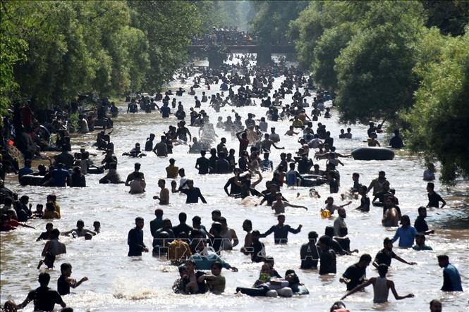 Người dân giải nhiệt trong ngày nắng nóng tại một con kênh ở Lahore, Pakistan. Ảnh: THX/TTXVN