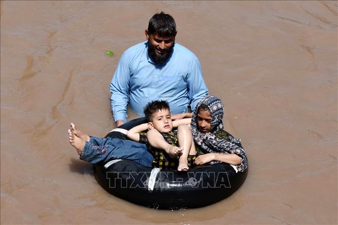Người dân giải nhiệt trong ngày nắng nóng tại một con kênh ở Lahore, Pakistan. Ảnh: THX/TTXVN