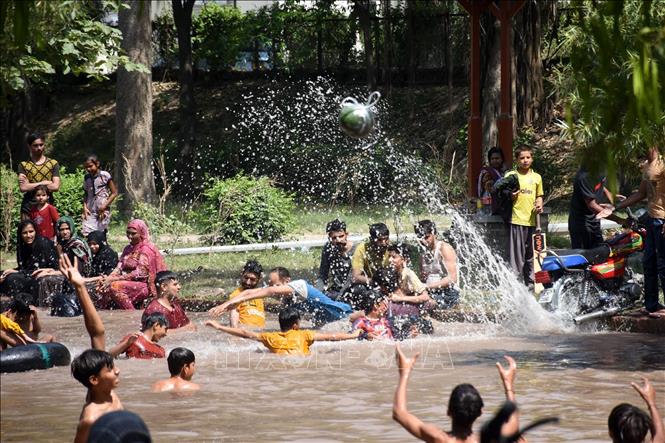 Người dân giải nhiệt trong ngày nắng nóng tại một con kênh ở Lahore, Pakistan. Ảnh: THX/TTXVN