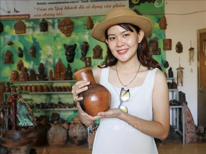 A tourist purchases a Cham pottery in Phuoc Dan township, Ninh Thuan province. VNA Photo: Nguyễn Thành