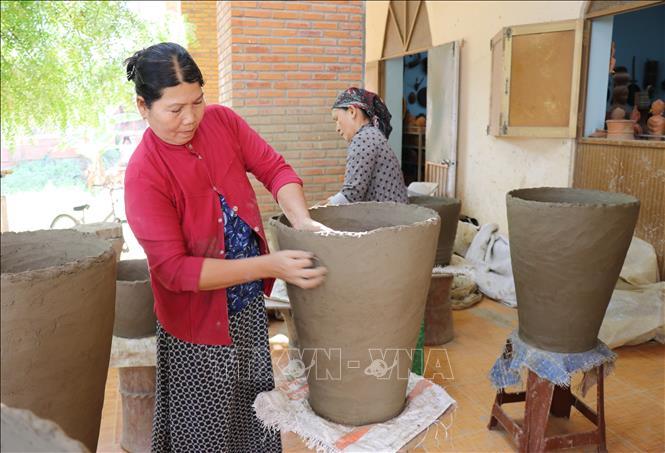 Unlike other traditional ceramic villages, Cham's pottery makers don't use turning tables to create their products but only use their skilled hands. Cham women move themselves backward around blocks of clay to shape objects. VNA Photo: Nguyễn Thành