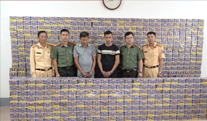 Hai đối tượng bị bắt giữ (giữa) và tang vật của vụ án tại cơ quan điều tra. Ảnh: TTXVN phát