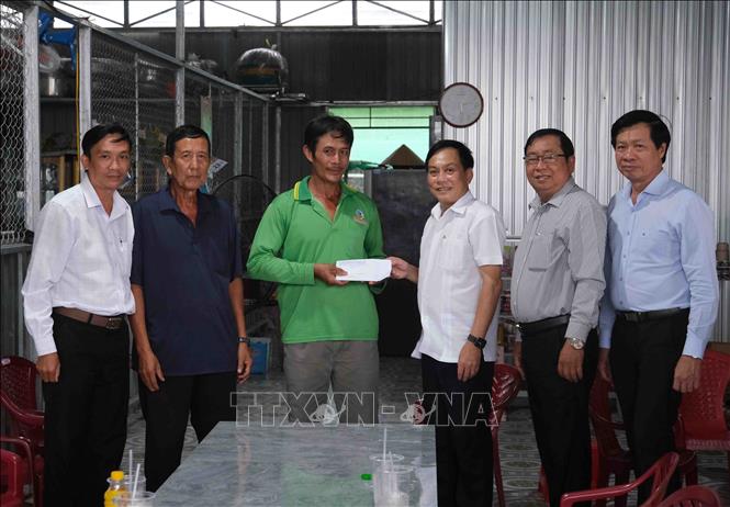 Phó Chủ tịch UBND thành phố Cần Thơ Nguyễn Ngọc Hè trao tiền hỗ trợ cho gia đình ông Nguyễn Văn Dũng có nhà bị sụp xuống sông Ô Môn trong vụ sạt lở ngày 20/5. Ảnh: Thanh Liêm - TTXVN
