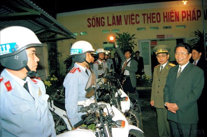 Chủ tịch nước Trần Đức Lương thăm, tặng quà và chúc Tết cán bộ, chiến sĩ chốt cảnh sát giao thông số 2, Phòng Cảnh sát giao thông Công an thành phố Hà Nội, làm nhiệm vụ trong đêm giao thừa Tết Kỷ Mão (1999). Ảnh: Trọng Nghiệp - TTXVN