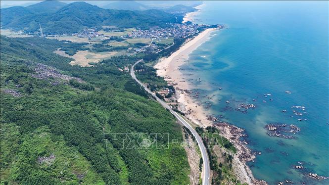 Cung đường uốn lượn giữa một bên là núi rừng, một bên là bờ biển trải dài. Ảnh: Hữu Quyết - TTXVN