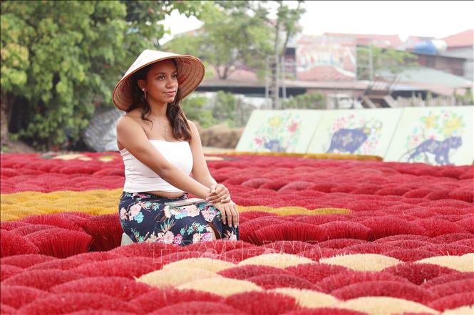 Du khách trải nghiệm nét văn hóa đặc sắc của Việt Nam tại làng hương Quảng Phú Cầu. Ảnh: Thành Phương – TTXVN