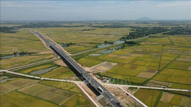 Cánh đồng lúa nằm cạnh tuyến đường cao tốc Bắc - Nam. Ảnh: Hữu Quyết – TTXVN