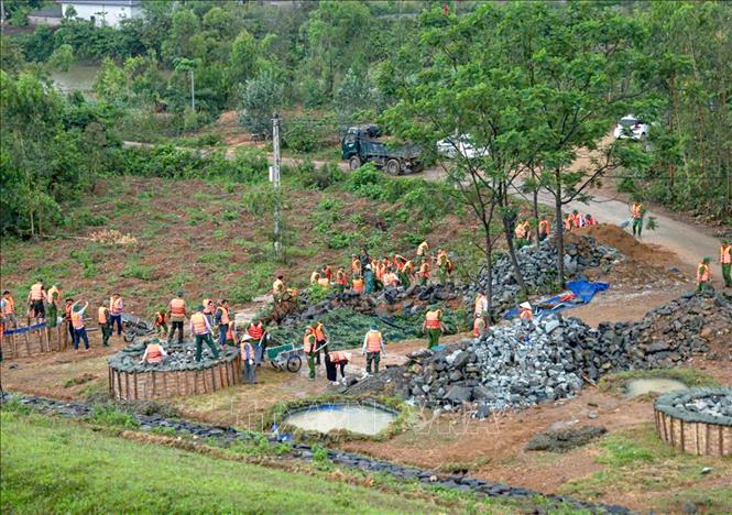 Các lực lượng tham gia diễn tập xử lý mạch đùn, mạch sủi tại chân đập Bàn Long, xã Minh Quang, huyện Tam Đảo. Ảnh: Hoàng Hùng - TTXVN 
