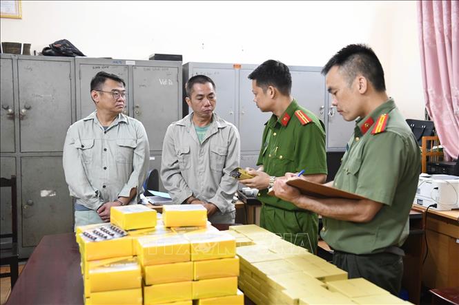 Lực lượng chức năng bắt giữ các đối tượng (trái) và tang vật vụ án. TTXVN phát