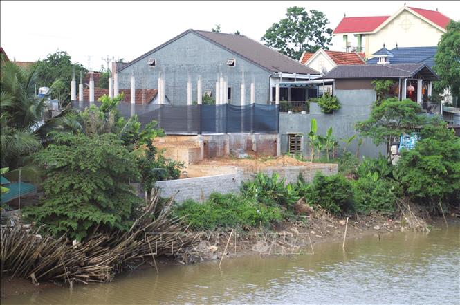 Dọc đường tỉnh lộ 533 qua địa bàn xã Đô Thành (huyện Yên Thành, Nghệ An) có nhiều công trình nhà ở đang xây dựng lấn chiếm hành lang kênh Vách Bắc. Ảnh: Xuân Tiến - TTXVN 
