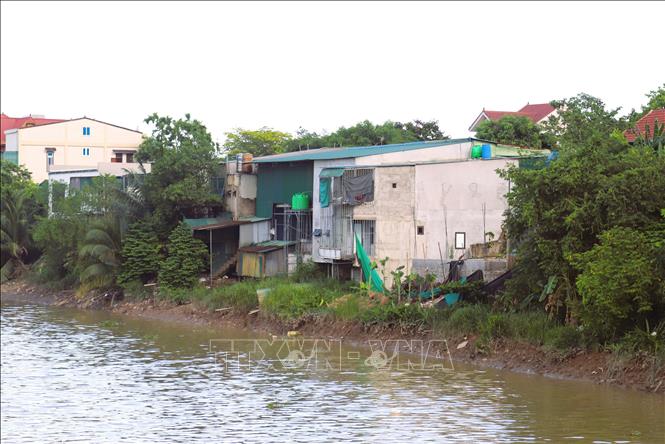 San sát nhà ở, công trình phụ được người dân xã Đô Thành (huyện Yên Thành, Nghệ An) xây dựng, cơi nới ngay trên hành lang thoát lũ của kênh Vách Bắc. Ảnh: Xuân Tiến - TTXVN 