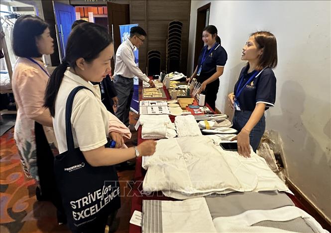 Khách tham quan tìm hiểu về sản phẩm buồng phòng thân thiện với môi trường tại Hội thảo. Ảnh: Trần Lê Lâm - TTXVN 