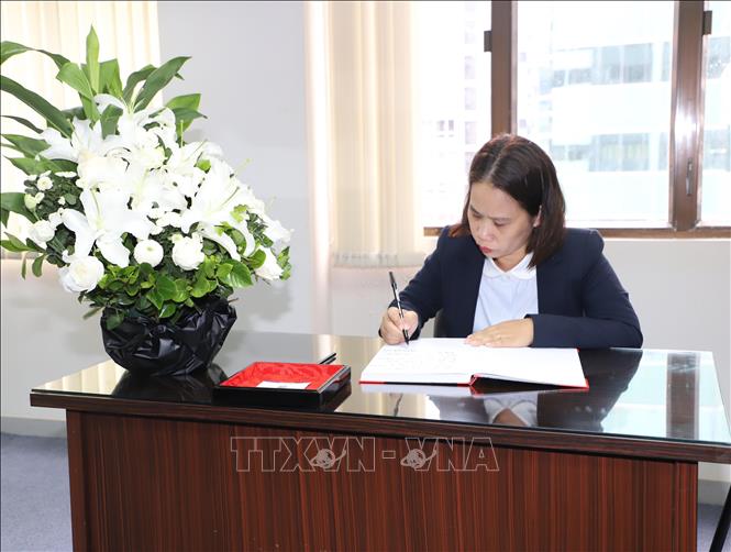 Trưởng Cơ quan thường trú TTXVN tại Hong Kong Mạc Thị Luyện ghi sổ tang nguyên Chủ tịch nước Trần Đức Lương. Ảnh: PV TTXVN tại Hong Kong (Trung Quốc)