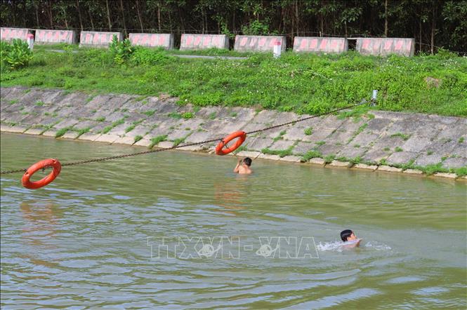 Sông Đào có mái lát nghiêng, trơn trượt do rêu bám nên hệ thống phao cứu sinh trở thành điểm tựa khá an toàn đối với các cháu nhỏ khi tắm sông.  Ảnh: Xuân Tiến - TTXVN 
