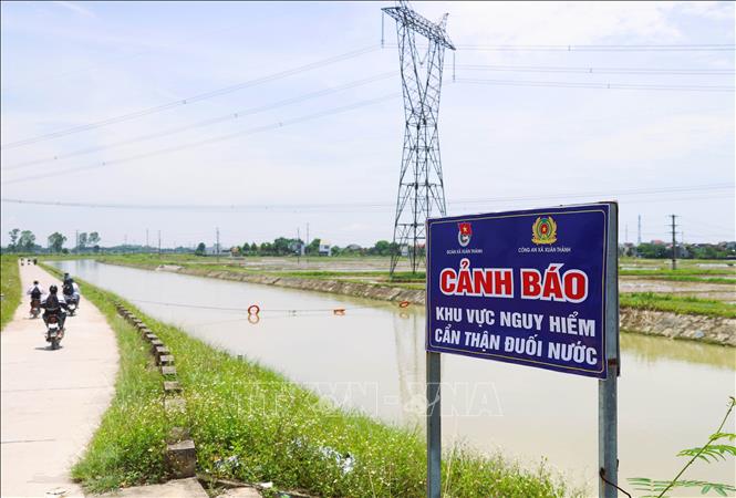 Biển cảnh báo nguy hiểm đuối nước được chính quyền địa phương, công an xã, đoàn xã lắp đặt tại nhiều khu vực trên dọc sông Đào. Ảnh: Xuân Tiến - TTXVN 