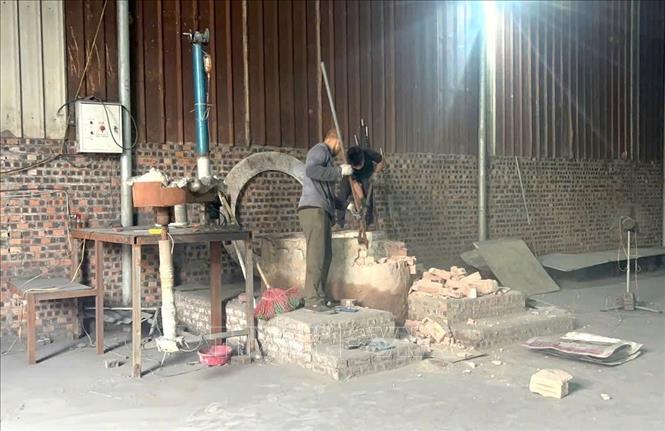 Người dân tại Văn Môn phá dỡ lò cô đúc nhôm. Ảnh: Thanh Thương - TTXVN