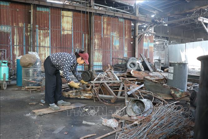 Người dân thu dọn nguyên liệu tại cụm công nghiệp Châu Khê, thành phố Từ Sơn sau khi dừng hoạt động. Ảnh: Thanh Thương - TTXVN