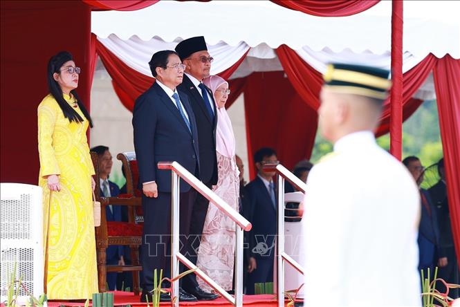 Thủ tướng Phạm Minh Chính và Thủ tướng Malaysia Anwar Ibrahim nghe quân nhạc cử Quốc thiều hai nước. Ảnh: Dương Giang-TTXVN