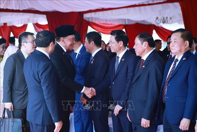 Thủ tướng Phạm Minh Chính giới thiệu với Thủ tướng Malaysia Anwar Ibrahim thành viên đoàn Việt Nam. Ảnh: Dương Giang-TTXVN
