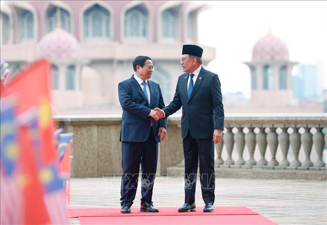 Thủ tướng Malaysia Anwar Ibrahim đón Thủ tướng Phạm Minh Chính. Ảnh: Dương Giang-TTXVN