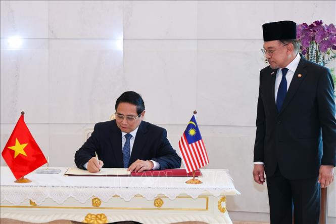 Thủ tướng Phạm Minh Chính ký sổ lưu niệm tại Phủ Thủ tướng Malaysia. Ảnh: Dương Giang-TTXVN