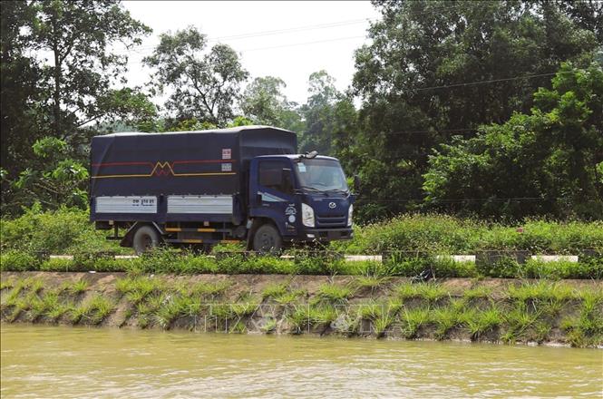 Xe tải có tải trọng lớn lưu thông trên đê của sông Đào. Ảnh: Xuân Tiến - TTXVN 