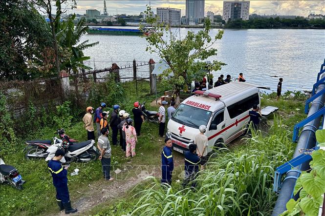 Lực lượng chức năng tỉnh Đồng Nai tìm kiếm, trục vớt thi thể bé gái bị nước cuốn trôi. Ảnh: Lê Xuân-TTXVN